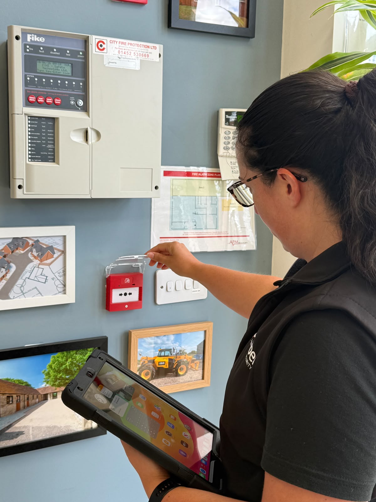 A lady looking at a fire alarm during a fire risk assessment