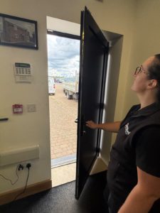 Fire Risk Assessor checking a fire door during a fire risk assessment inspection.